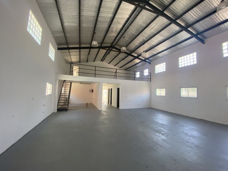 Interior de nave industrial terminada, con entrepiso, escalera metálica y cubierta a dos aguas
